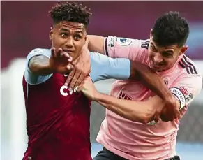  ??  ?? Serious offence: Sheffield United’s John Egan (right) tussles with Aston Villa’s Ollie Watkins. Egan was sent off for the challenge. — AP