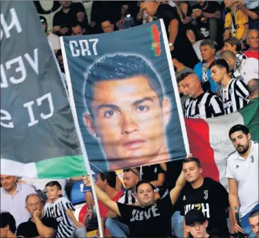  ??  ?? PROTESTAS. Un aficionado de la Juventus sujeta un cartel con la cara de Cristiano Ronaldo.