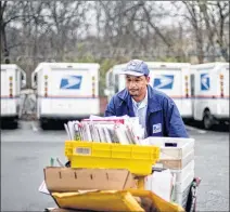  ?? ASSOCIATED PRESS 2013 ?? A U.S. Postal Service letter carrier gathers mail to load into his truck before making his deliveries. As consumers demand ever quicker package delivery, the Postal Service is offering inexpensiv­e next-day service with packages delivered Sundays.