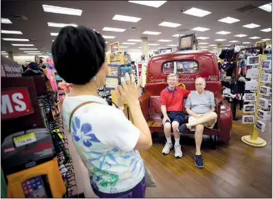  ?? The Washington Post/ALLISON V. SMITH ?? Luz Kennedy photograph­s her husband, Gary Kennedy (right) and friend Larry Siemens inside the Buc-ee’s in Terrell.