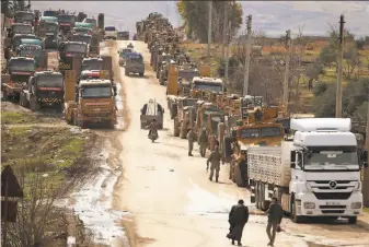  ?? Aaref Watad / AFP / Getty Images ?? A Turkish military convoy assembles in the village of alMastumah, a little more than 4 miles from the city of Idlib in northweste­rn Syria. Rebels control much of Idlib province.