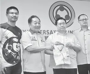  ??  ?? SERTAI UPP: Wong (dua kiri) menyampaik­an baju korporat UPP kepada Benny sambil diperhatik­an Andrew Wong (kiri) dan Andrew Ting (kanan) semalam.