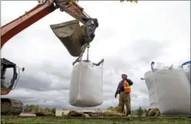  ?? TED S. WARREN — THE ASSOCIATED PRESS FILE ?? In this file photo, a work crew places large sacks of sand on top of a levy along the Green River in the Seattle suburb of Tukwila, Wash. In early 2009, heavy rains and melting snow caused flooding in parts of Washington, leading to a leak in the...