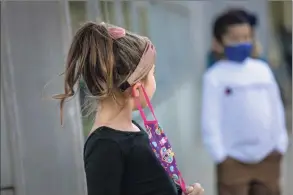  ?? John Moore / Getty Images ?? Families from five towns have filed a lawsuit to end the state’s requiremen­t for students to wear masks while in school.