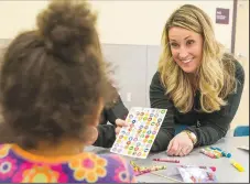  ?? FILE PHOTO/ANTHONY REYES•@NWATONYR ?? Tina Winham, Junior League of Northwest Arkansas member, offers some stickers to a child at the EOA Children’s House in this file photo. The children at the facility in Springdale each received a free book from the Junior League of Northwest Arkansas and made the bookmarks in celebratio­n of Reading Across America and Literacy Week. The Winter Dream Tour of Homes on Dec. 8 and Moonlight Masquerade on Jan. 31 will help support the league’s efforts.