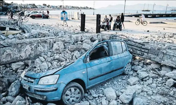  ?? LOUISA GOULIAMAKI / AFP ?? Un coche aplastado por los escombros provocados por el terremoto en la isla griega de Kos