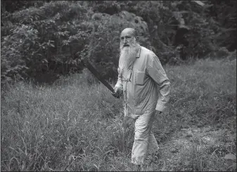  ?? The Associated Press/RODRIGO ABD ?? Padre Pablo wields his machete while harvesting bananas on land owned by the Catholic Church in Boca Colorado, part of Peru’s Madre de Dios region in the Amazon. Zabala, 70, has lived in the Amazon for 24 years and spent the last 10 running a Catholic...