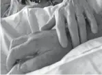  ?? KRISTEN JORDAN SHAMUS/DETROIT FREE PRESS ?? Diane Jordan holds the hand of her husband, Butch Jordan, on a hospital bed where he lay dying.