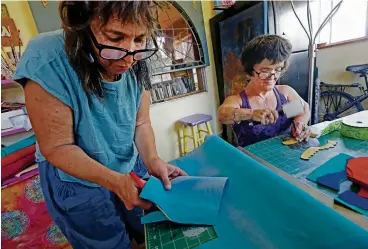  ??  ?? ABOVE: Lisa G. McDonough, left, and partner Lesley Sneider make shoes for little people last month at McDonough’s home in Santa Fe. McDonough quit a bookkeepin­g job last month to focus on the business.