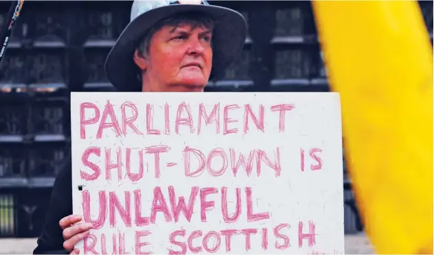  ?? Associated Press ?? ↑ A pro-eu protester shows a poster in front of the Houses of Parliament entrance in London on Wednesday.