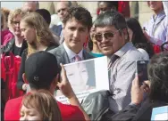  ?? CP PHOTO ADRIAN WYLD ?? Prime Minister Justin Trudeau poses Wednesday for a photo with an attendee at the Families of Sisters in Spirit Vigil in support of missing and murdered indigenous women on the steps of Parliament Hill.