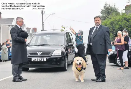  ?? GAYLE MARSH ?? Chris Needs’ husband Gabe walks in front of the funeral car with their golden retriever Buster Llyr