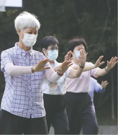  ?? CHIANG YING-YING/THE ASSOCIATED PRESS ?? People wear face masks to protect against the spread of COVID-19 during morning exercises at a park in Taipei, Taiwan, Wednesday, even though the government has not required face coverings outdoors for many since July.