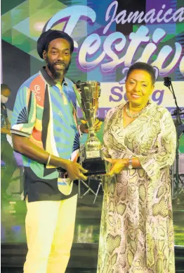  ?? CONTRIBUTE­D ?? Minister of Culture, Gender, Entertainm­ent and Sport Olivia Grange (left) presents the Jamaica Festival Song Trophy to Buju Banton. The reggae singer won the 2020 Jamaica Festival Song Competitio­n with his song ‘I am a Jamaican’.