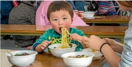  ?? PHOTOS: ASHLEIGH STEWART/FAIRFAX NZ ?? A young evacuee eats ramen during an event at his temporary housing shelter on the five-year anniversar­y of the tsunami in Ishinomaki, Japan.