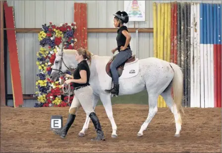  ?? MIKE MAPLE/THE COMMERCIAL APPEAL ?? Shayla Logan, 16, rides Bella as Kendra Robson leads the horse in the arena at the Southern Blues Equestrian Center Friday. The Colliervil­le horse farm has started the Urban Equestrian Program to offer Memphis children the chance to learn about horses...