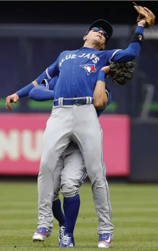  ?? KATHY WILLENS/THE ASSOCIATED PRESS ?? Troy Tulowitzki, front, suffering a cracked left shoulder blade in a collision with centre fielder Kevin Pillar.