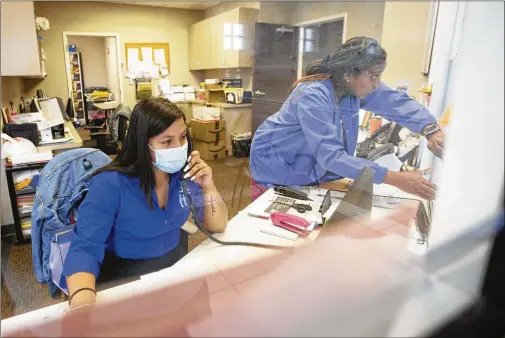  ?? MIGUEL MARTINEZ / FOR THE AJC ?? The Good Samaritan Health Center in Atlanta conducts telemedici­ne 24 hours a day, seven days a week, amid strict sanitary measures during the pandemic to lessen direct contact. Nurses triage patients as they enter, and the center operates a health care hotline that receives about 1,000 calls each day.