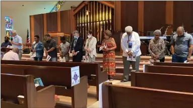  ?? EVAN BRANDT — MEDIANEWS GROUP ?? The Rev. Carter Lester, second from left, leads a prayer for the 10people killed May 14in a racially-motivated shooting in Buffalo, NY. Each person standing represents one of the dead.