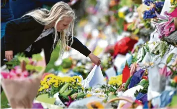  ?? Foto: Anthony Wallace, afp ?? Trauernde legen Blumen nieder, um der getöteten Muslime zu gedenken. Mindestens 50 Todesopfer sind es inzwischen: Das Massaker in zwei Moscheen wird Neuseeland wohl dauerhaft verändern.