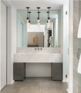  ??  ?? Left: Marble finishes detail the master bathroom at 1113 Arroyo Drive in Pebble Beach. Below: The contempora­ry home features an open floor plan with custom chandelier­s and ambient lighting. Architect Conrad Sanchez of Conrad Asturi Studios designed the...