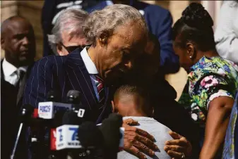  ?? Joshua Bessex / Associated Press ?? The Rev. Al Sharpton comforts Jaques Patterson, son of shooting victim Heyward Patterson, at a news conference outside the Antioch Baptist Church on Thursday in Buffalo, N.Y.