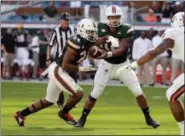 ?? LYNNE SLADKY — ASSOCIATED PRESS ?? Miami quarterbac­k Malik Rosier, right, hands off to running back Travis Homer during the first half of the Hurricanes’ 44-28 win over Virginia at Miami Gardens, Fla., on Nov. 18.