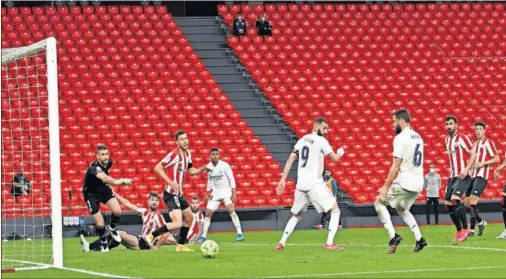  ??  ?? El balón se dirige a la portería defendida por Unai Simón en el remate de Nacho con el que el Madrid marcó el gol de la victoria ante el Athletic.