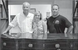  ?? STAFF PHOTOS BY DARWIN WEIGEL ?? Schoenbaue­r Furniture Service owner Bill Schoenbaue­r, left, his daughter, Katie Morgan, and brother, Mike Schoenbaue­r, stand with a piece of furniture that underwent restoratio­n in the Charlotte Hall shop. The business is celebratin­g 25 years and...