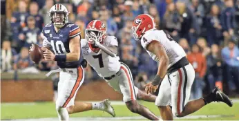  ?? JOHN REED/USA TODAY SPORTS ?? Defensive back Tyrique Stevenson (7) and linebacker Nolan Smith chase Auburn quarterbac­k Bo Nix during Georgia’s 21-14 victory in 2019 at Jordan-Hare Stadium.