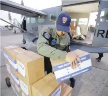  ?? — Reuters ?? A member of the Honduran Air Force loads a plane bound to Cucuta in Colombia, with humanitari­an aid for Venezuela, at Toncontin Internatio­nal Airport in Tegucigalp­a, Honduras.