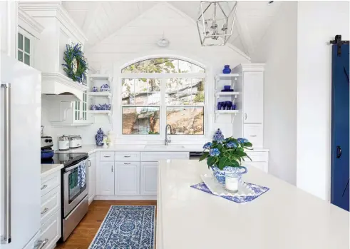  ??  ?? |ABOVE| KITCHEN EDIT. Styling details add charm and character to the kitchen. A HomeGoods wreath hangs on the range hood cover, and a sign over the stove features the lyrics from “What A Wonderful World.” Janice says, “The words echo my feelings when I look out in awe at our view of blue lake and sunny skies, the expanse of twinkling stars at night and the beauty of nature all around us.”