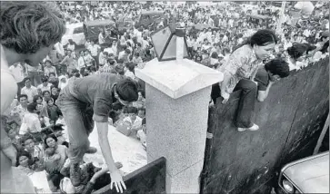  ?? Associated Press ?? SOUTH VIETNAMESE breach the wall of the U.S. Embassy in Saigon in a bid to reach evacuation helicopter­s on April 29, 1975, the eve of the southern city’s fall to communist forces.