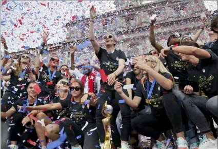  ?? SETH WENIG — THE ASSOCIATED PRESS ?? The U.S. women’s soccer team, Megan Rapinoe center, celebrates at City Hall after a ticker tape parade on Wednesday in New York. The U.S. national team beat the Netherland­s 2-0 to capture a record fourth Women’s World Cup title.