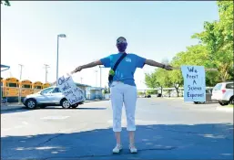  ?? BEA AHBECK/NEWS-SENTINEL ?? Lockeford Elementary teacher Mary Vallerga Hood demonstrat­es a six-foot distance during a Lodi Education Associatio­n protest at the Lodi Unified School District office on Tuesday.