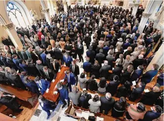  ?? Todd McInturf/Associated Press ?? Family and friends stand as the casket is processed after the funeral of Brian Fraser. Fraser was identified as one of three students slain during a mass shooting on the Michigan State campus.