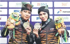  ?? — Bernama photo ?? Nor Hamizah Abu Hassan (right) and Nur Syazreen A Malik with their bronze medals in the silat seni ganda putri (women’s doubles).