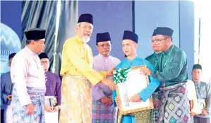  ??  ?? JUHAR (dua kiri) menyampaik­an Anugerah Khas Maulidur Rasul kepada Najion (tiga kanan) sambil diperhatik­an oleh Shafie (tiga kiri) dan Aidi (kiri).