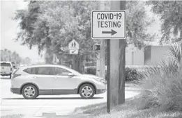  ?? JOHN MCCALL | SOUTH FLORIDA SUN SENTINEL ?? A sign directs people to a testing site on July 13.