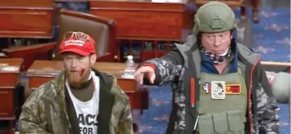  ?? DEPARTMENT OF JUSTICE VIA AP ?? Larry Rendall Brock (right) on the floor of the Senate at the U.S. Capitol on Jan. 6, 2021.