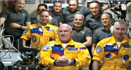  ?? ?? BOLD STATEMENT: Russian astronauts, from left, Sergey Korsakov, Oleg Artemyev and Denis Matveev, in their yellow uniforms on the Space Station