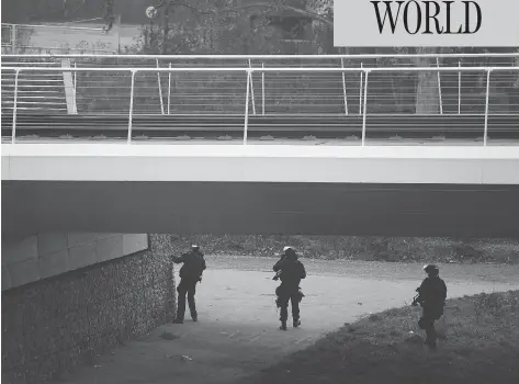  ?? FREDERICK FLORIN / AFP / GETTY IMAGES ?? Members of the French police special forces RAID conduct searches on a bank of the river Rhine in Strasbourg on Wednesday in their hunt for the gunman who opened fire near a Christmas market Tuesday night in Strasbourg, France. Two have died and 13 are injured.