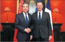  ?? ZHAO DINGZHE / XINHUA ?? Wang Yi, foreign minister and director of the Office of the Central Commission for Foreign Affairs, shakes hands on Tuesday with French President’s Diplomatic Counselor Emmanuel Bonne during the 25th China-France Strategic Dialogue in Paris.