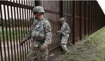  ?? Jerry Lara / Staff photograph­er ?? U.S. troops deployed to the U.S.-Mexico border secure razor wire to the wall near downtown Brownsvill­e.