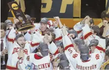  ?? AP PHOTO ?? WHAT A WEEKEND: Hobey Baker Award winner Will Butcher (left) raises the national championsh­ip trophy after Denver beat Minnesota-Duluth in last night’s Frozen Four title game in Chicago.