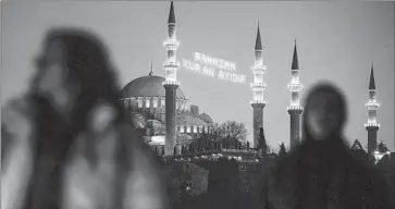  ?? Emrah Gurel Associated Press ?? MAHYA, a 400-year-old Turkish tradition of stringing Ramadan messages between minarets, could be in its twilight. This message at Istanbul’s Suleymaniy­e Mosque reads: “Ramadan is the month of Quran.”