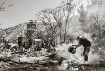  ?? Sarah Reingewirt­z / Associated Press ?? Dale Burton of Leona Valley, Calif., tries to douse embers Monday after the Bobcat Fire destroyed a friend’s home.