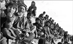  ??  ?? Afghan spectators watching horsemen compete in the traditiona­l sport of buzkashi.