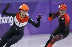  ?? AP PHOTO/BERNAT ARMANGUE ?? Suzanne Schulting of the Netherland­s celebrates as she wins women's 1,000-metre short track speedskati­ng ahead of Kim Boutin, right, of Canada in the Gangneung Ice Arena at the Olympics in South Korea, Thursday.