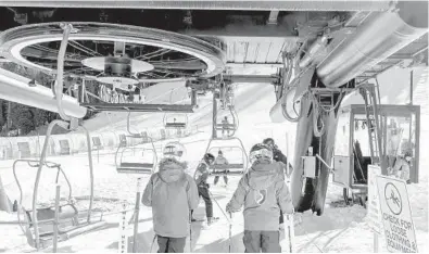  ?? CAYCE CLIFFORD/THE NEWYORKTIM­ES ?? Skiers board the Red Dog chairlift Dec. 12 at Squaw Valley Ski Resort in Olympic Valley, California. The resort felt“so dead,”said skier Sabrina Nottingham. The coronaviru­s pandemic also hit ski resorts in the spring.